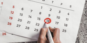 Person Circling Date on Calendar